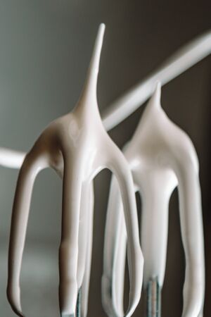 Baking concept. Whipped cream of egg whites for perfect peaks in a glass bowl, with a mixer on a marble white table. Meringue cookie recipeの写真素材