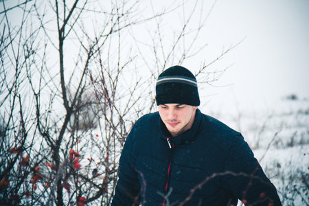 Happy young man with snowboard enjoying sunny weather in snowy mountains. Winter sport and...