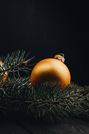 Christmas or New Year toy decorations golden balls and fur tree branch rustic on wooden background, top view, copy spaceの写真素材