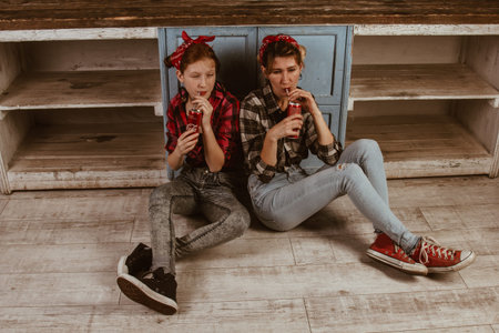 Ukraine. Kiev - 11,25,2019 drink Coca-Cola through a straw, smiling at each other, sitting at home in the kitchen. Advertising, new year concept. Pin-up photoの写真素材
