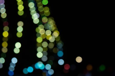 Golden abstract yellow, orange bokeh lights isolated on black background with copy space. Holiday and Christmas season concept, graphic resources, greeting card. wallpaper. Multi-colored lightsの写真素材