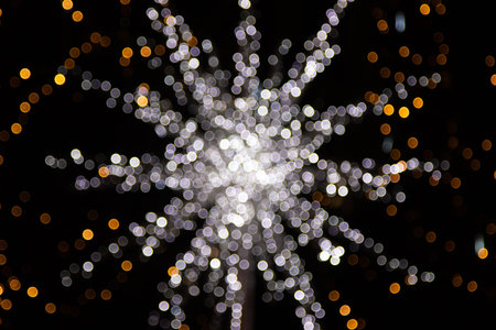 Golden abstract yellow, orange bokeh lights isolated on black background with copy space. Holiday...