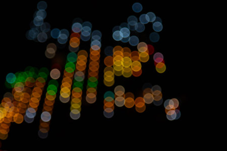 Golden abstract yellow, orange bokeh lights isolated on black background with copy space. Holiday...