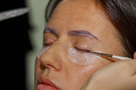 Beauty treatment. Closeup woman's face with paint on eyelashes. laminating eyelashes. Side view