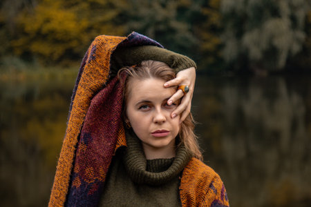 hide and seek. the girl covered her face with her hands. Close-up portrait on a lake background. The...