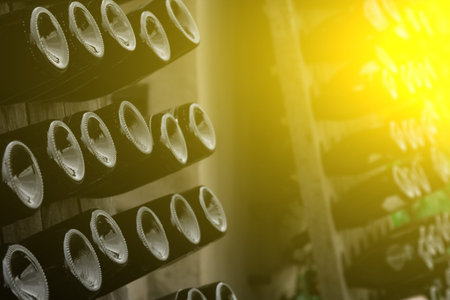 The bottom of the wine bottles is displayed on shelves in the open air. Creative dark and textured...