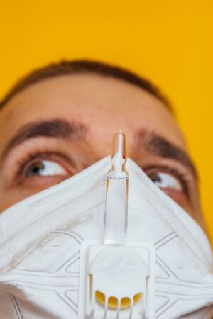 scared in medical mask looks in camera. Scared man in fear of coronavirus stands in protective medical mask against viruses and infections isolated studio. Coronavirus 2019-ncov covid-19 conceptの写真素材