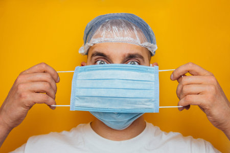 The guy puts on a respiratory mask over his eyes. Attractive man puts on a mask and looks at the...