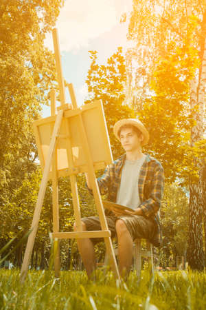 Autumn photo of the artist in the park. Photo in warm colors. Against the background of yellow foliageの写真素材
