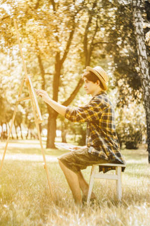 Autumn photo of the artist in the park. Photo in warm colors. Against the background of yellow foliageの写真素材