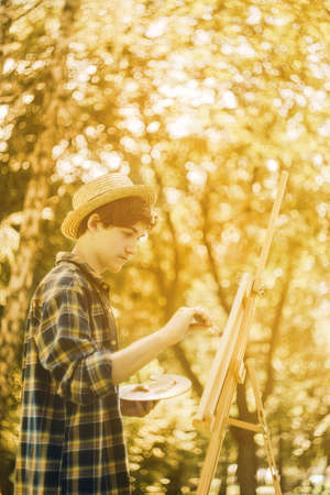 Autumn photo of the artist in the park. Photo in warm colors. Against the background of yellow foliageの写真素材
