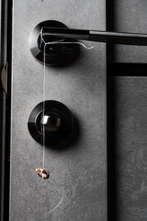method of tooth extraction. A real human wisdom tooth hangs by a thread on a doorknob. Dentistry...