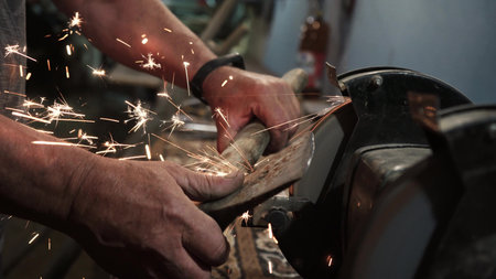 Sharpening an ax on an electric grinding wheel, Machine sharpening an ax on an electric grinder,...