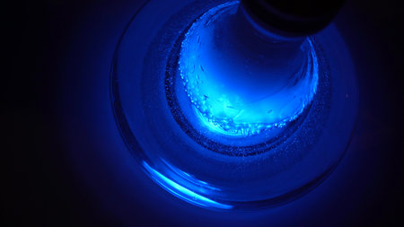 Close up of glass transparent flask of hookah on the table with a cloud of smoke. Shisha flask under...