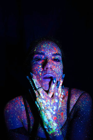 Portrait of a beautiful woman with blue sequins on her face. Girl with artistic make-up in Light color. fashion model with colorful makeupの写真素材