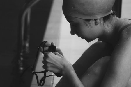 Synchronized girl working out tricks in the pool. Synchronized swimming, sports in the water. Professional sportswoman doing exercises in the pool. Training before the competitionの写真素材