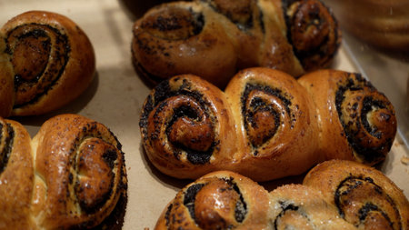 Rows of Warm Freshly Baked Bread Rolls on Display in Bakery Stand at Local Grocery Store
