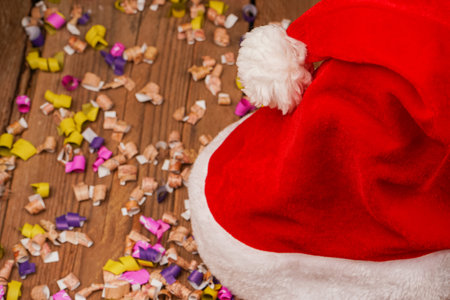 Top view photo of Christmas Flatlay gift box and Christmas tree decorations. Santa hat on a wooden background. Christmas background with place for text. Copyspace. Christmas tree toysの写真素材