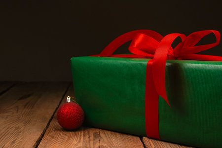 Festive gift box and golden Christmas tree decorations on wooden background. Holiday concept. Christmas, New Year, birthday, women's holidayの写真素材