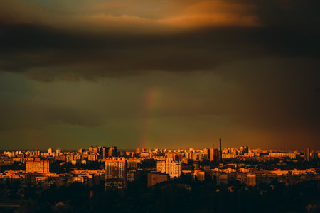 rainbow appeared against gray stormy sky over residential area of the city.の写真素材
