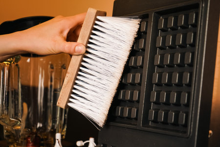 Filthy waffle maker. Dirty waffle maker with burnt batter to the surface. The work surface of an old electric waffle iron. Cleaning waffle maker. Cleaning kitchen.の写真素材