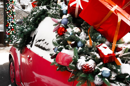 Christmas decorated classic car. A vintage car decorated for the holidays loaded with festive gifts A classic Christmas automobile decorated with bells and garland and loaded with presents.の写真素材