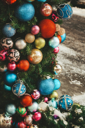 Red, white, blue and green decorations on tree branches. Christmas tree decoration, Decor for winter holidays. Home decoration in winter. Festive mood. Christmas background.の写真素材