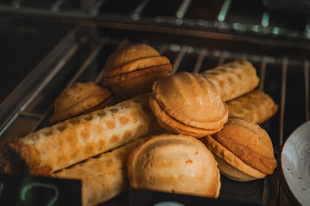 Modern bakery or patisserie. A dessert of nuts with condensed milk with a pie nearby. A display case of a bakery or coffeeshop. Various types of mini desserts in a display case.の写真素材