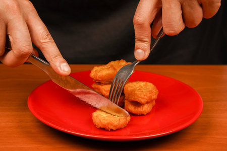 Man eating chicken nuggets. Chicken nuggets on plate. Chicken nuggets with ketchup. Fast food. Junk food. Unhealthy lifestyle.の写真素材