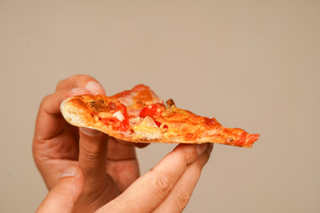 Tasty food at pizzeria. Concept of takeaway. Fast food order. Restaurant advertising. Delicious cheesy pizza. Pizza. Unhealthy food. Junk food. Fatty food. Hand taking pizza slice, close up view.の写真素材