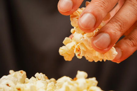 Grabbing popcorn in hand. Delicious snack to eat in the cinema. Salted popcorn. Popcorn. Fast food....