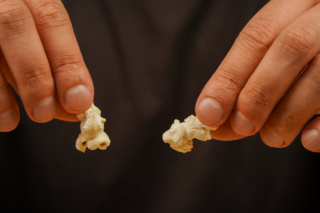 Delicious snack to eat in the cinema. Salted popcorn. Popcorn. Snack for cinema. Man holding popcorn to eat.の写真素材