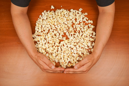 Flavored spicy popcorn scattered on table surface. Delicious snack to eat in the cinema. Salted...
