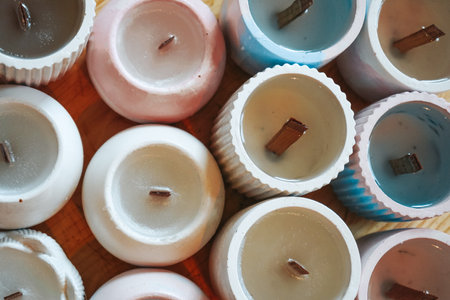 Many soy wax candles together on store or workshop background, top view. Ecological and vegan business. Soy candles poured into recycled bottles and jars.の写真素材