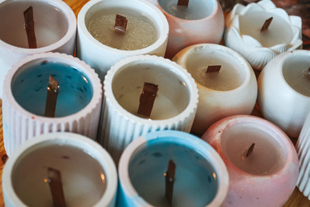 Manufacture and production of scented candles. Craft wax candle, top view. Process of pouring melted coconut wax and placing the wick in candle jars.の写真素材
