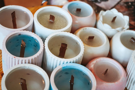 Soy candles poured into recycled bottles and jars, top view. Many soy wax candles together on store or workshop background. Ecological and vegan business.の写真素材