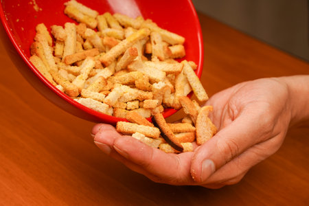 Croutons. Croutons in bowl. Wooden background. Salty snack for beer. Snack.の写真素材