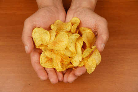 Fast food. Junk food. Unhealthy lifestyle. Man eating potato chips. Hand holds potato chips. A view...