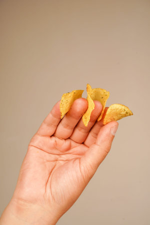 Unhealthy lifestyle. Man eating potato chips. Hands hold potato chips.の写真素材