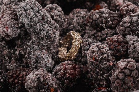Silver ring close-up. Jewelry on the background of frozen raspberries. Summer berries as a background for jewellery.の写真素材