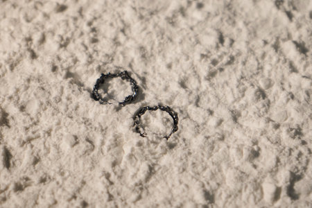 Silver ring with big pearl and diamonds on white sand. Copy spaceの写真素材