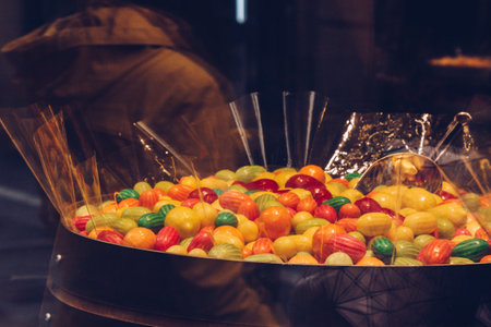 Prague, Czech Republic - May 11, 2019. Local sweet store. A bunch of colorful dragees. Candies in multicolored glaze. Candy shop in Europe. Metal scoop inside. Basket full of colorful candies.の写真素材
