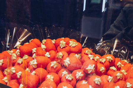 Prague, Czech Republic - May 11, 2019. Candy shop in Europe. Basket full of red candies with white flowers on top. Local sweet store. A bunch of colorful dragees. Candies in multicolored glaze.の写真素材