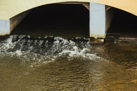 Prague, Czech Republic - May 11, 2019: Rivers water flowing from a tunnel. A river in Prague. River in city,の写真素材