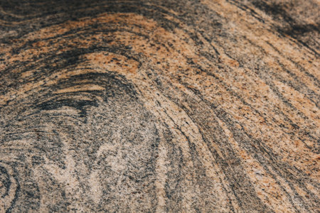 Vienna, Austria - May 12, 2019: Surface displaying intricate natural patterns. Stone features various shades of brown and beige with some lighter and darker swirls, circles, lines creating abstract.の写真素材
