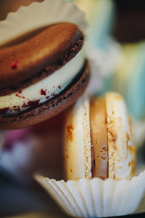Elegant selection of assorted macarons in different pastel colors. Close-up highlights the texture of the dessert filling. As a concept for French cuisine, desserts and confectionery themes.の写真素材