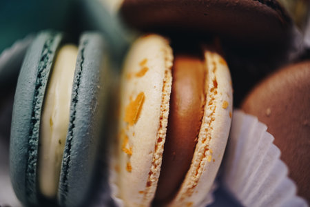 Elegant selection of assorted macarons in different pastel colors. Close-up highlights the texture of the dessert filling. As a concept for French cuisine, desserts and confectionery themes.の写真素材