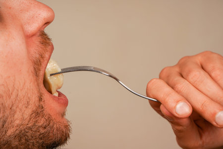 A close-up of a person savoring dumplings on a fork, highlighting the texture of the dish and the...