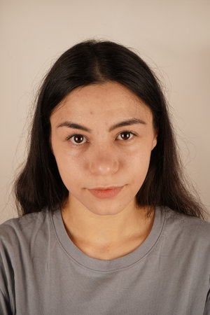 A close-up of a womans face showcases her calm and relaxed demeanor. Her natural beauty and soft expression convey peace and tranquility. The composition highlights simplicity and ease.の写真素材