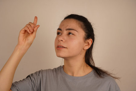 It is a classic symbol of awareness and discovery. The raised index finger indicates inspiration, drawing attention to a thought. This gesture emphasizes alertness and intellectual activity.の写真素材